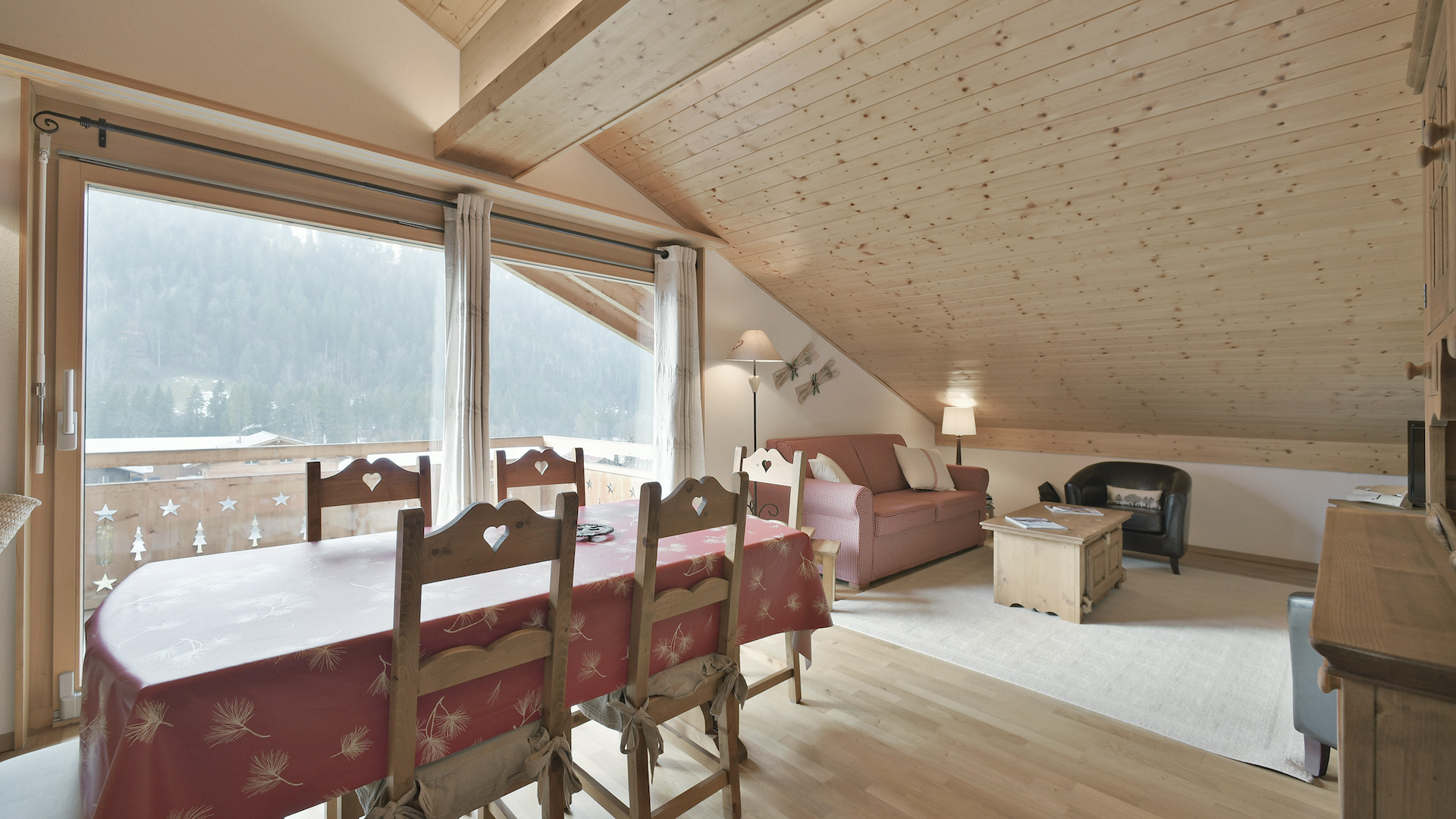 Gemütlicher Dachgeschoss-Wohnraum mit Essbereich und Balkonblick