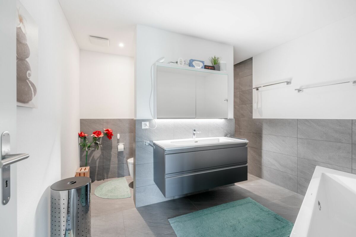 Modernes Badezimmer mit grauen Fliesen und Doppelwaschtisch