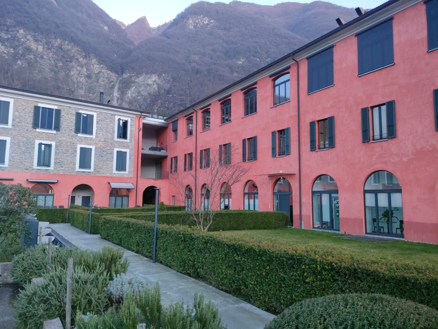 Innenhof mit farbiger Wohnanlage vor Bergkulisse