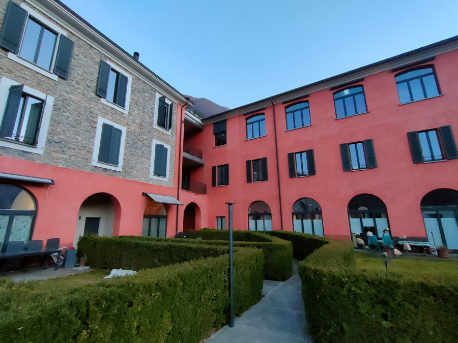 Innenhof eines mehrgeschossigen Wohngebäudes mit begrünten Wegen