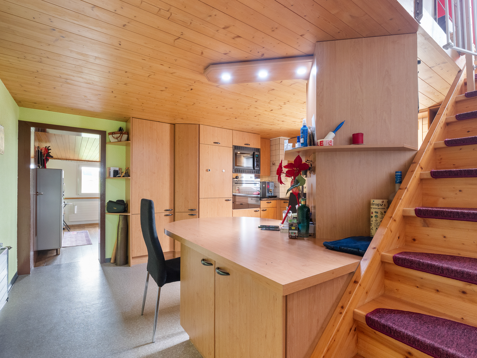 Offene Küche mit Holztreppe und Dachschräge