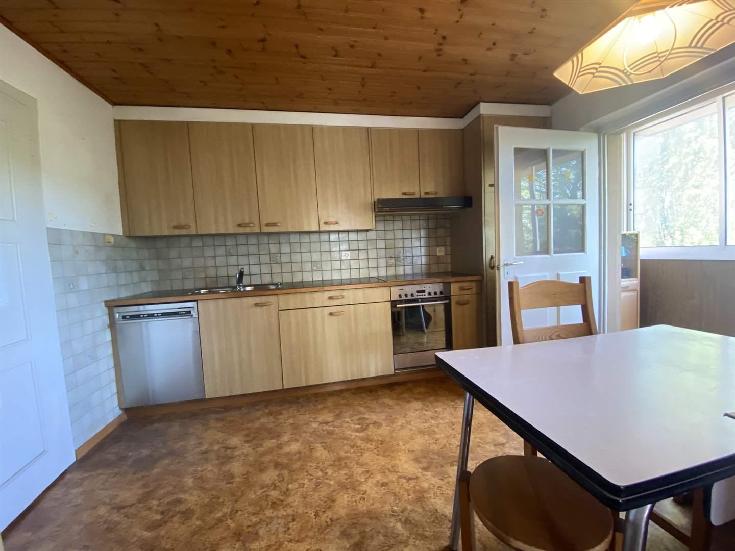 Küche mit Holzfronten und Essbereich