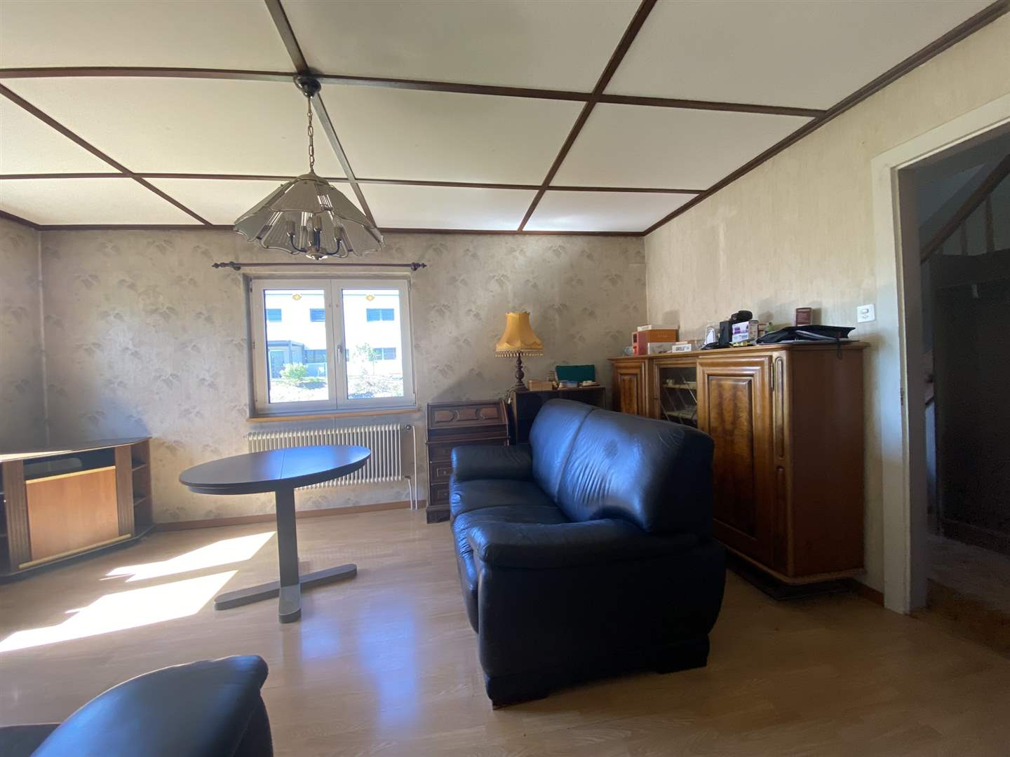 Wohnzimmer mit Sitzmöbeln und Holzschrank