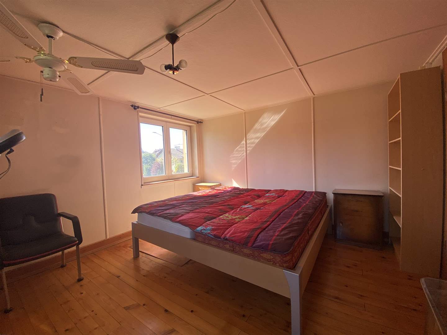 Schlafzimmer mit Holzboden und Doppelbett
