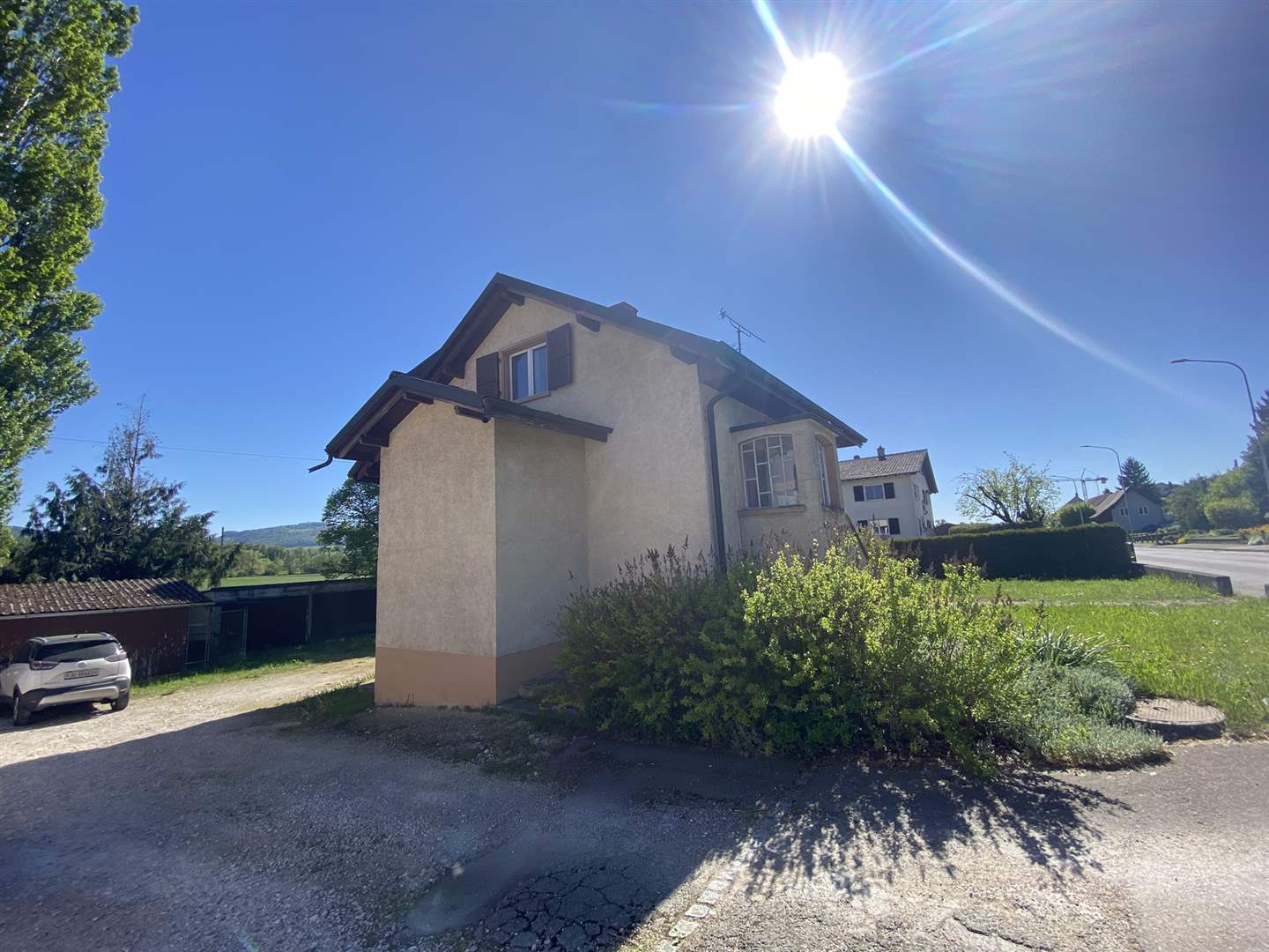 Einfamilienhaus mit Vorgarten an sonnigem Straßeneck