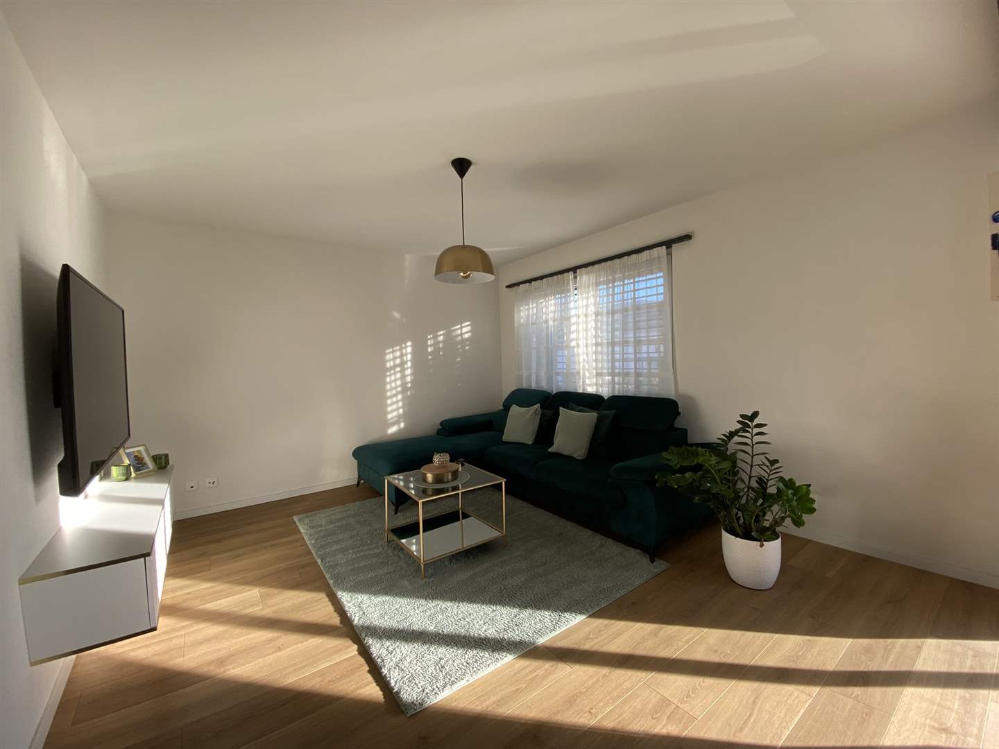 Helles Wohnzimmer mit Sofa und TV