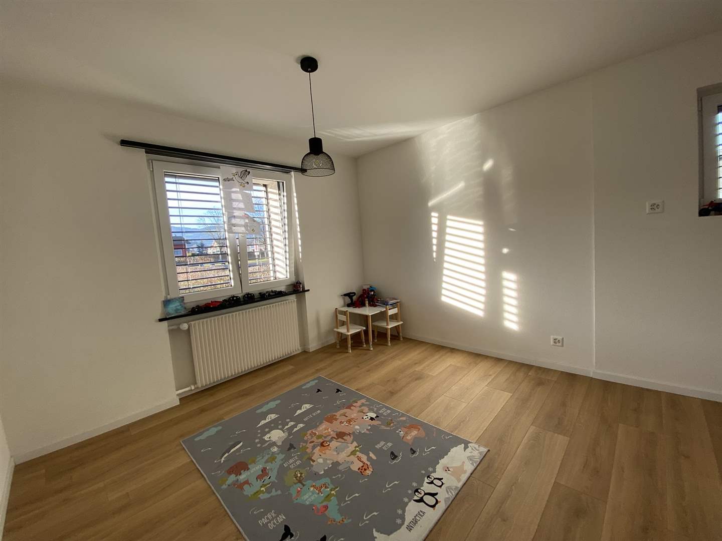 Helles, leeres Kinderzimmer mit Holzboden