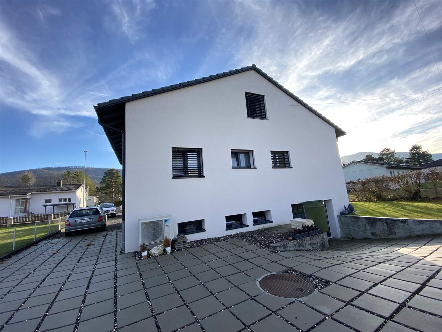 Außenansicht eines Einfamilienhauses mit gepflasterter Zufahrt
