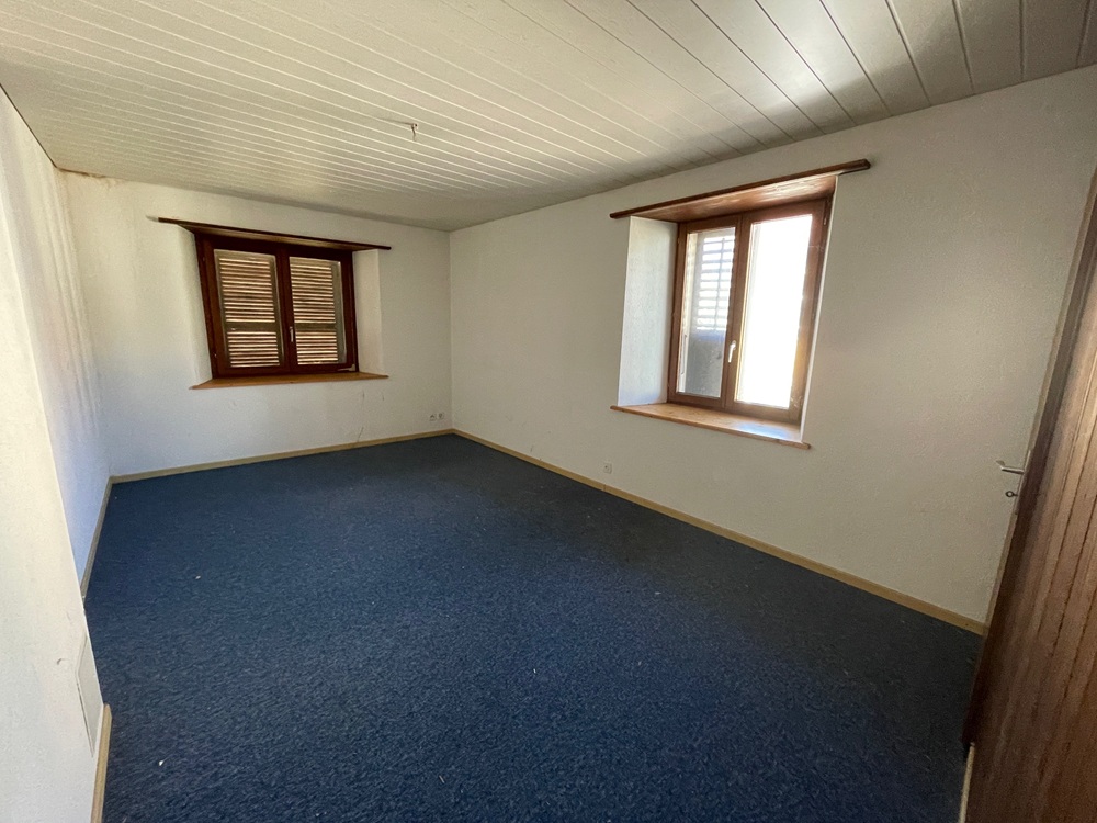 Leeres Zimmer mit Teppichboden und Holzfenstern