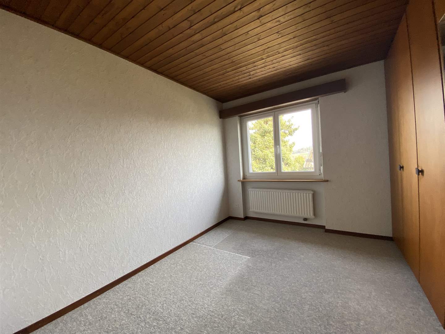 Leerer Raum mit Holzdecke und Fenster