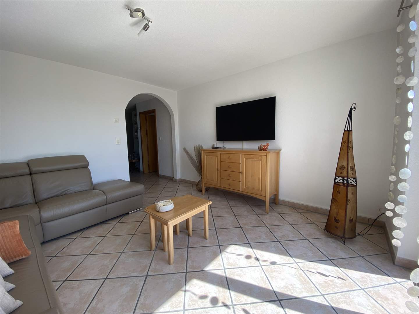 Helles Wohnzimmer mit TV und Sofa