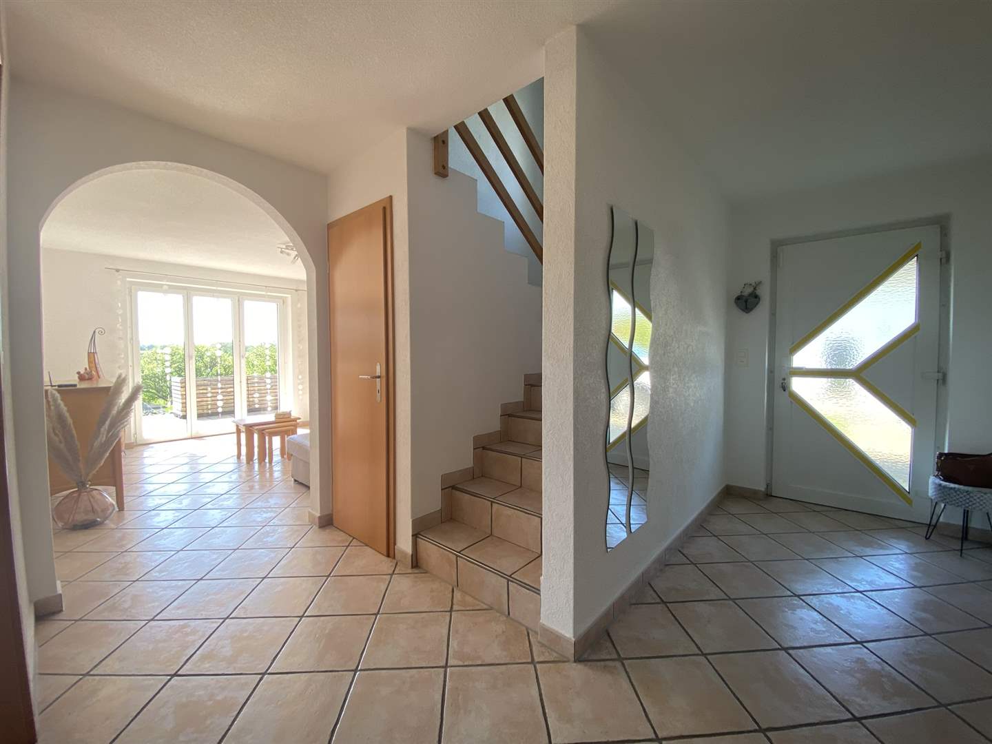 Heller Eingangsbereich mit Treppe und Blick in den Wohnraum