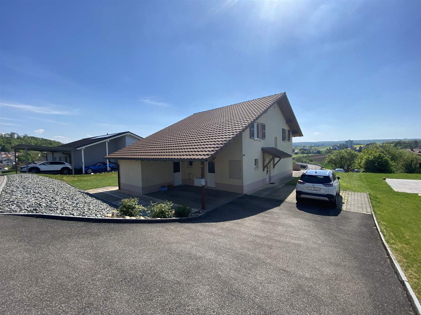 Moderne Hausansicht mit Auffahrt und Carport