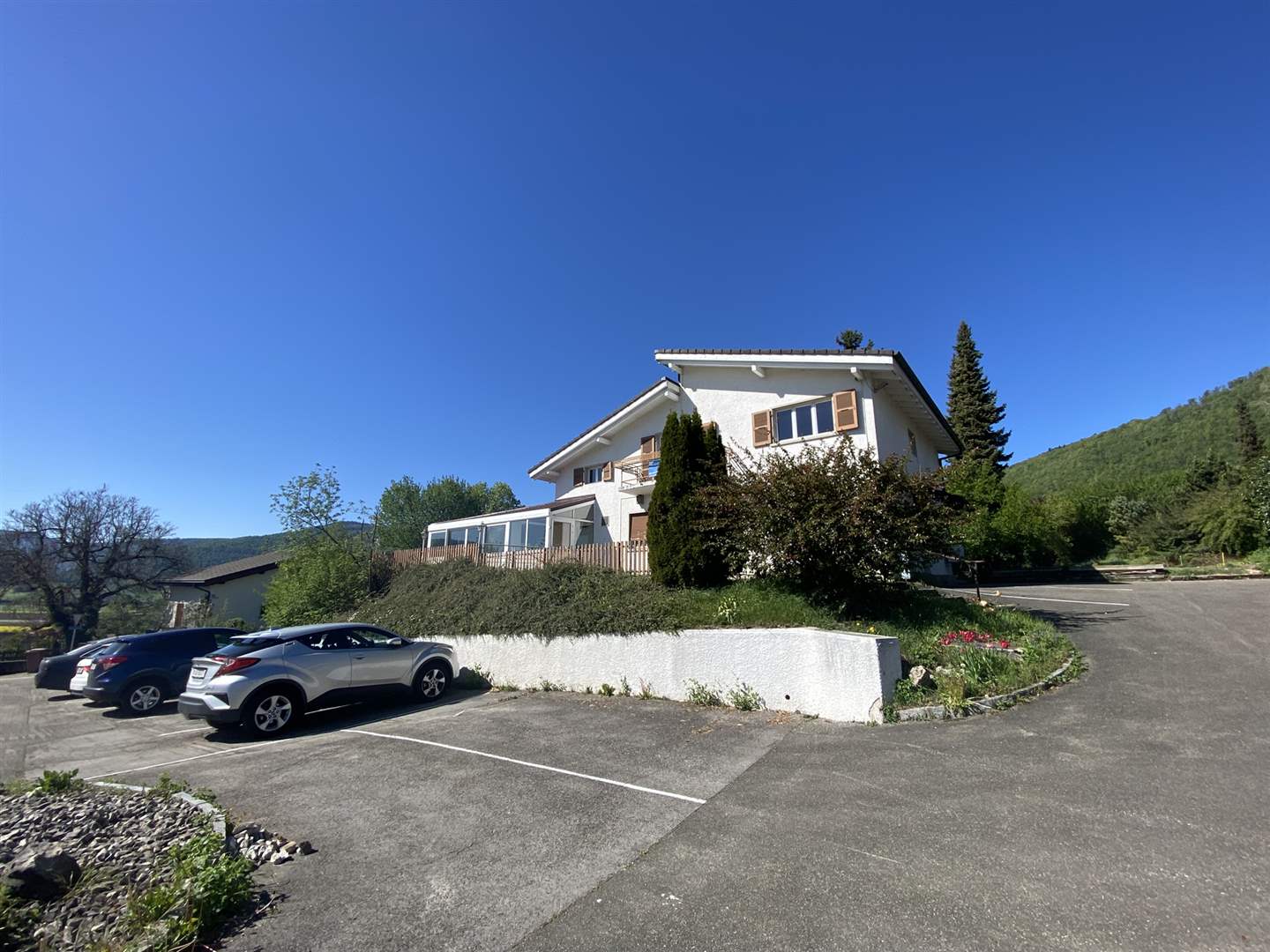 Wohnhaus mit Parkplatz in grüner Hanglage