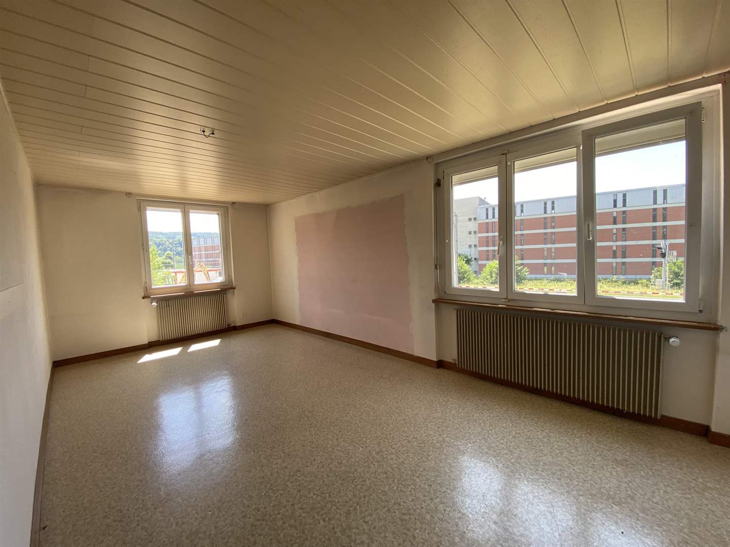 Heller leerer Wohnraum mit großen Fenstern