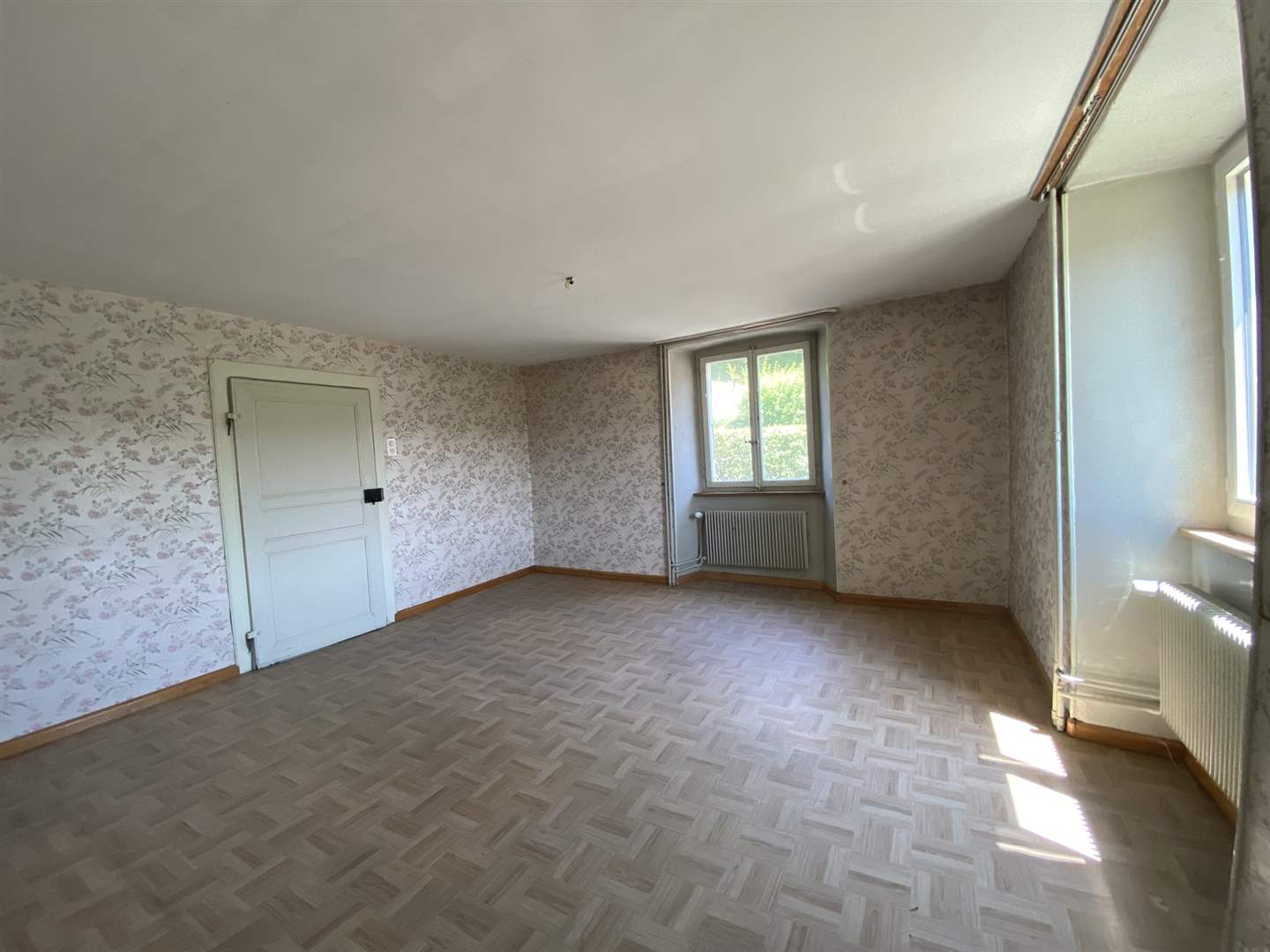 Leerer Altbau-Raum mit Blumen-Tapete