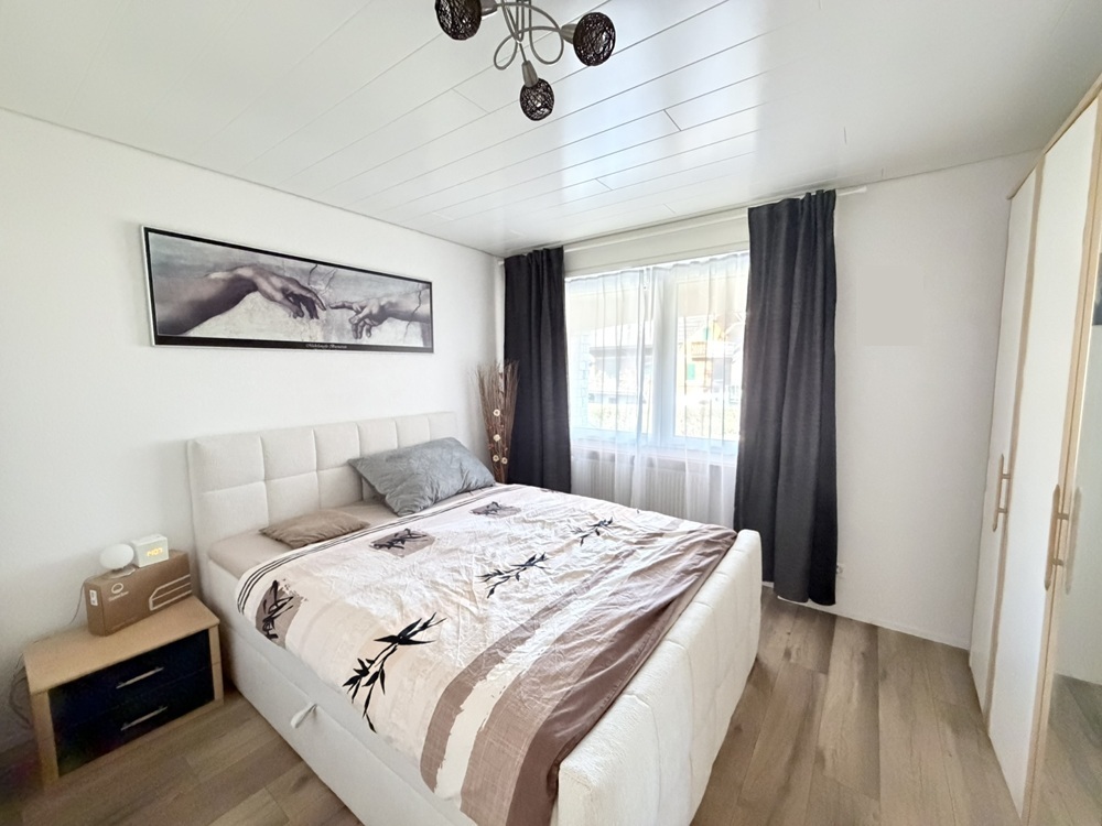Helles Schlafzimmer mit Fenster und Kleiderschrank