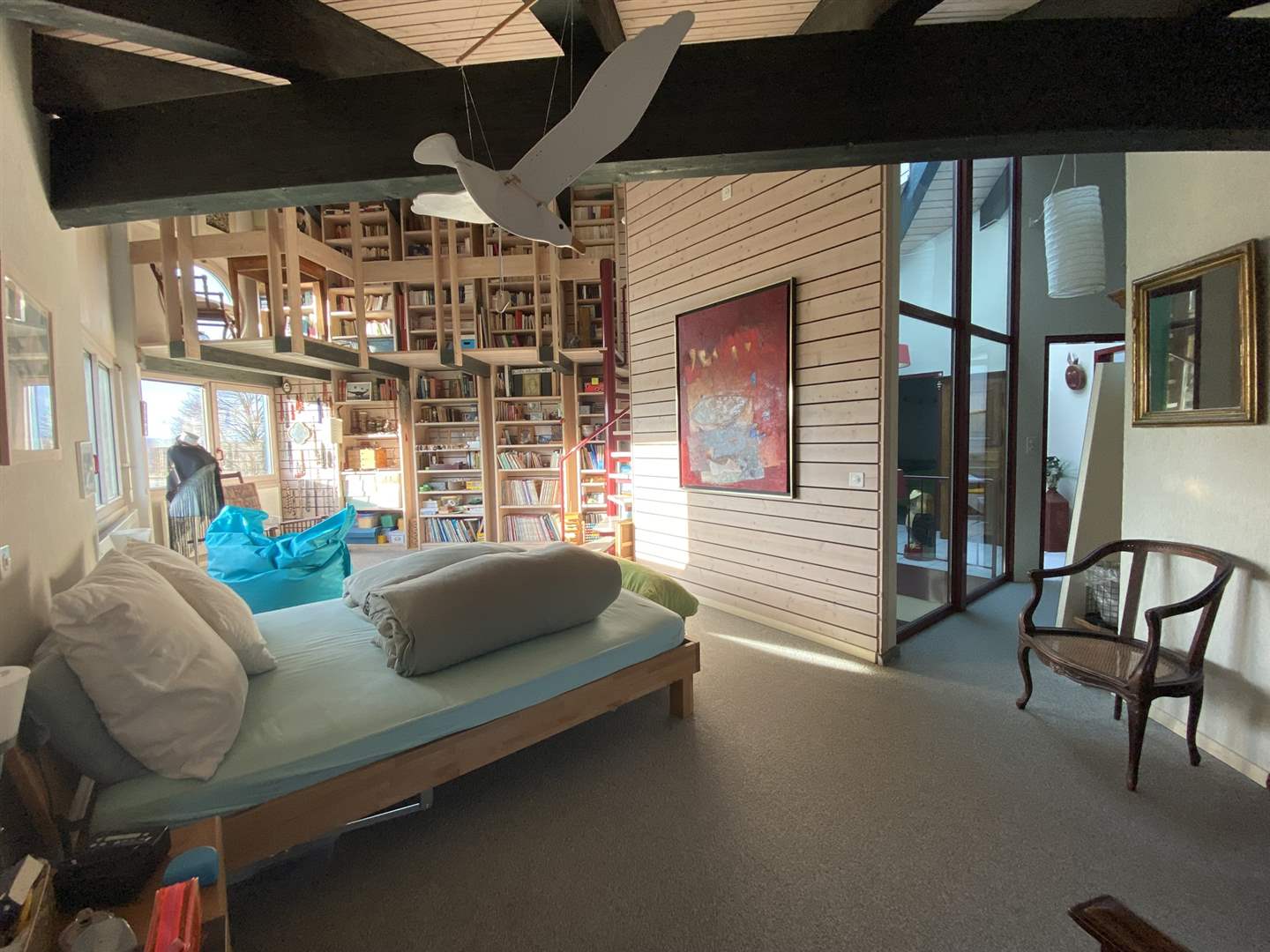 Lichtdurchflutetes Wohn-Schlafzimmer mit Bibliothekswand
