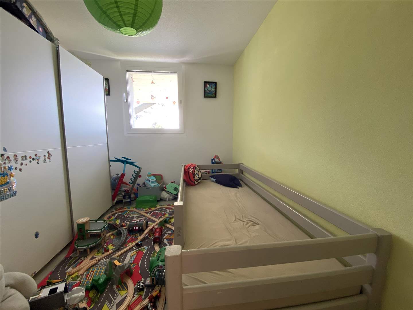 Kinderzimmer mit Bett und Spielteppich