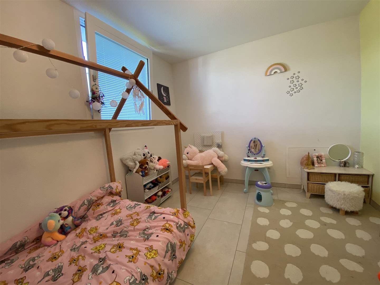 Kinderzimmer mit Spielbereich und Hausbett
