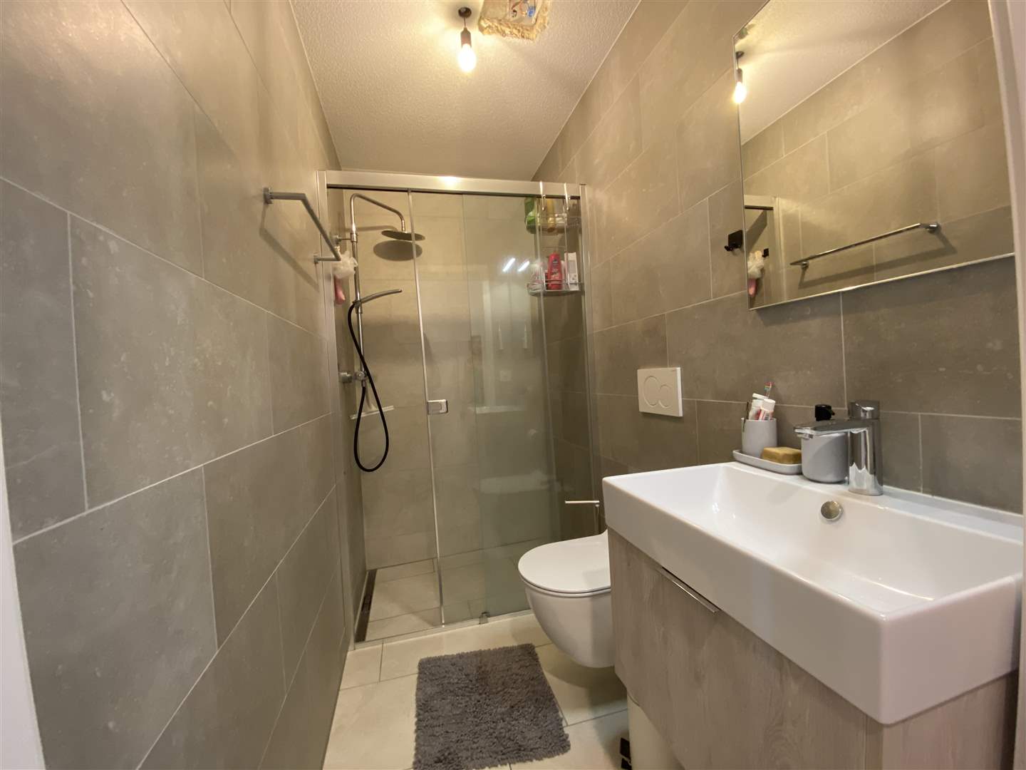Modernes Bad mit Dusche und Waschtisch