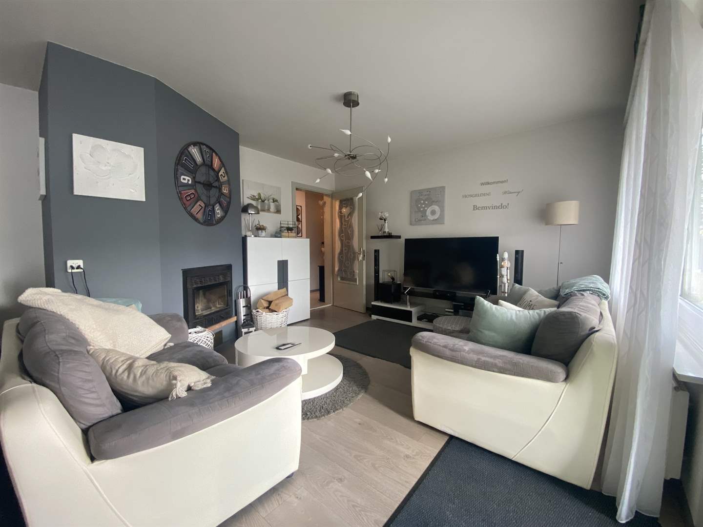 Helles Wohnzimmer mit Kamin und TV-Ecke