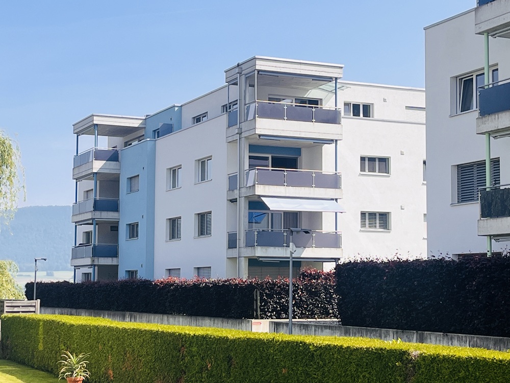 Mehrfamilienhaus mit Balkonen und Gartenblick