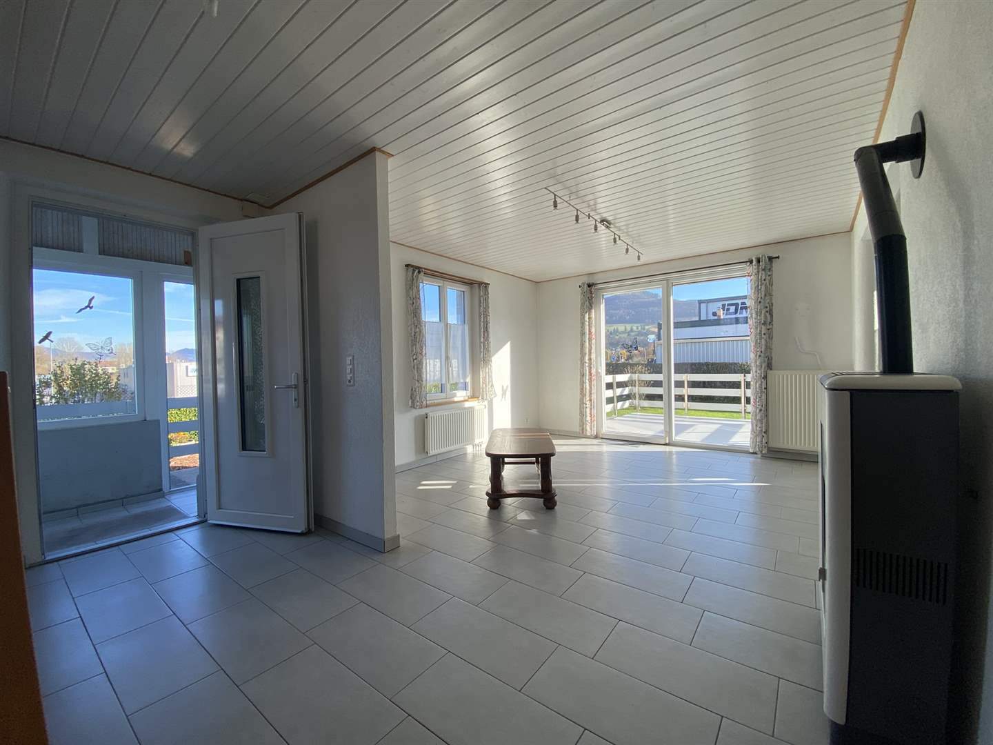 Heller Wohnraum mit Ofen und Terrasse