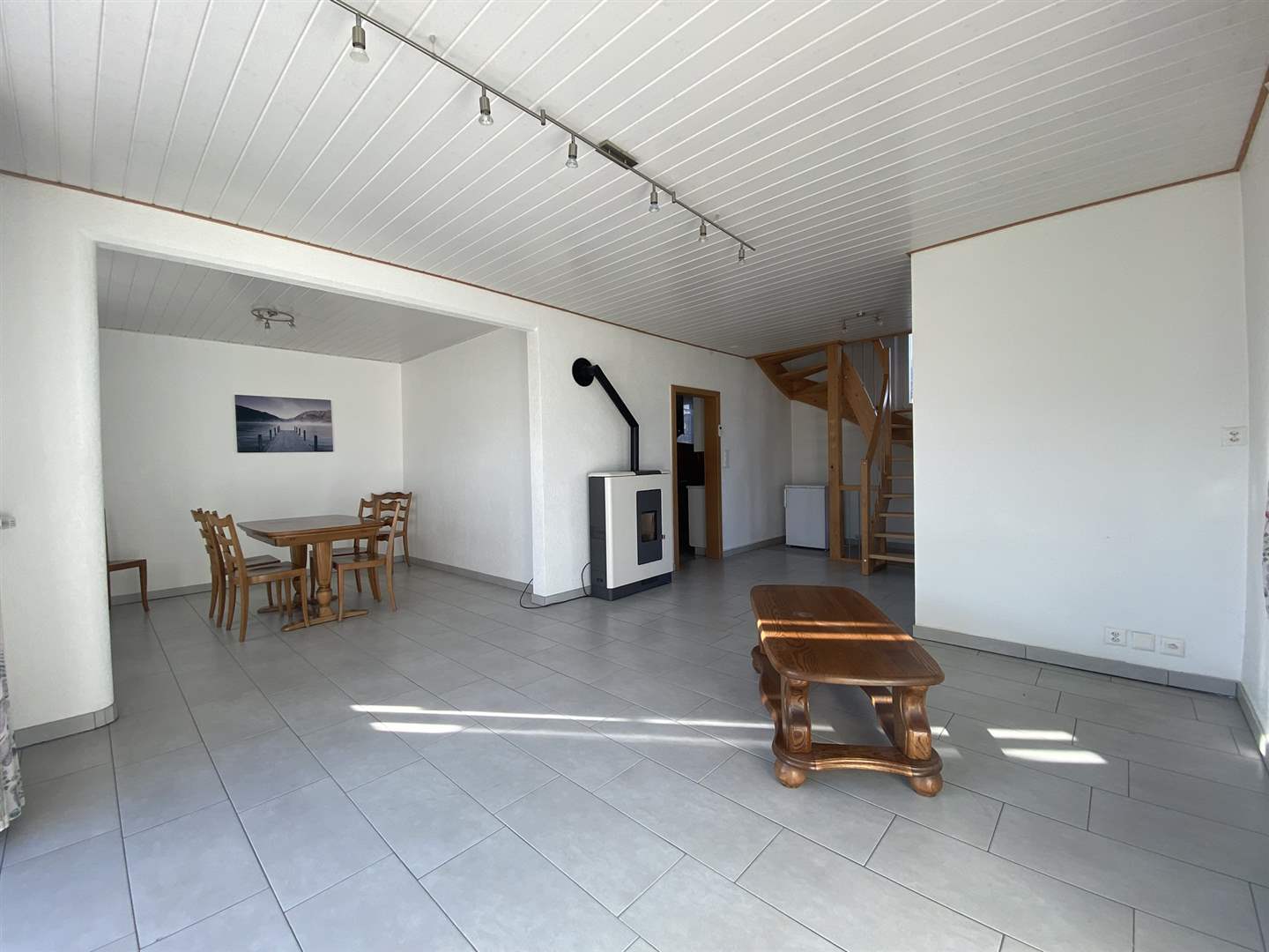 Heller Wohn- und Essbereich mit Holzofen und Treppe