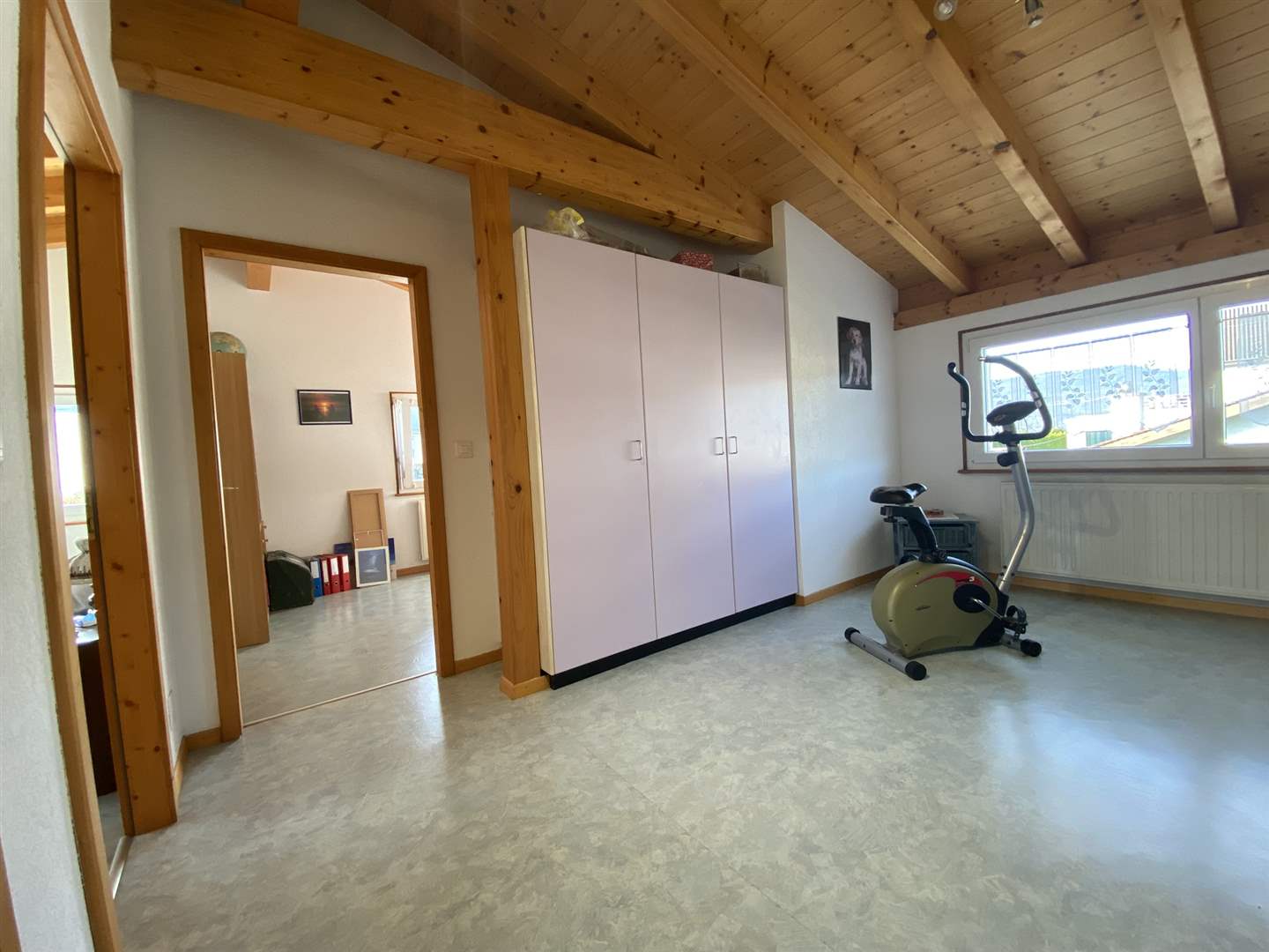 Dachgeschosszimmer mit Holzdecke und Sportgerät