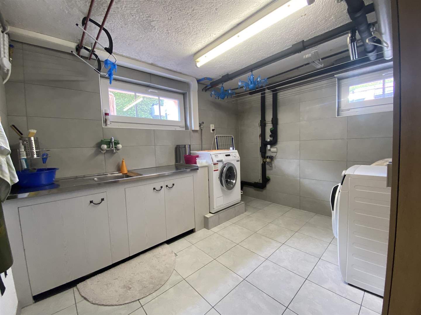 Hauswirtschaftsraum mit Waschmaschine und Spüle