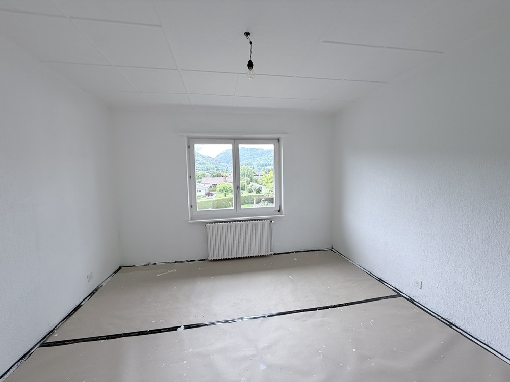 Leerer heller Raum mit Fenster und Heizkörper