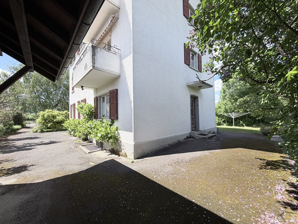 Außenansicht eines Wohnhauses mit Balkon und Garten