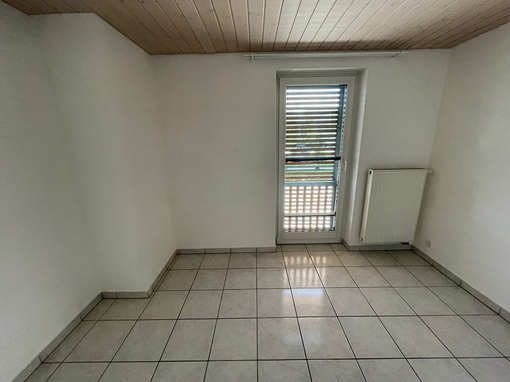 Leerer Raum mit Fliesenboden und Holzdecke