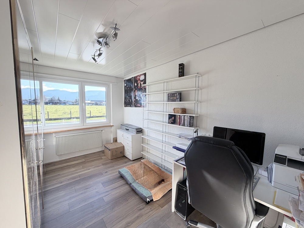 Arbeitszimmer mit Schreibtisch und Regal