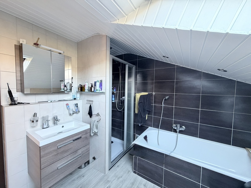Modernes Dachbad mit Badewanne und Waschplatz