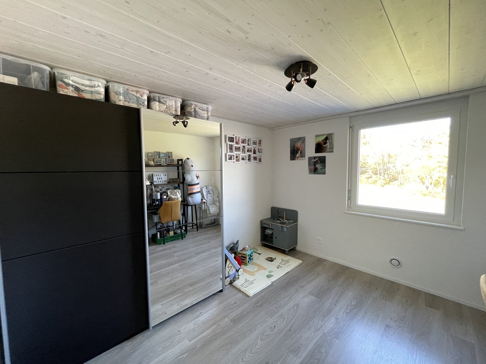 Helles Schlafzimmer mit Fenster und Kleiderschrank