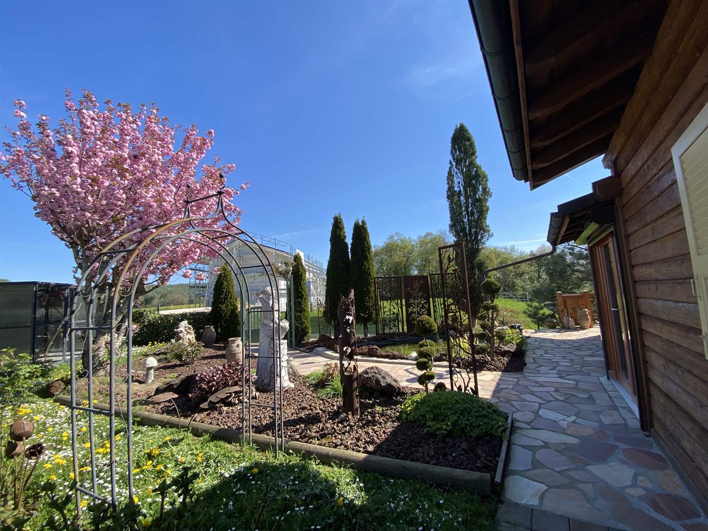 Garten mit Zierpflanzen und Holzfassade