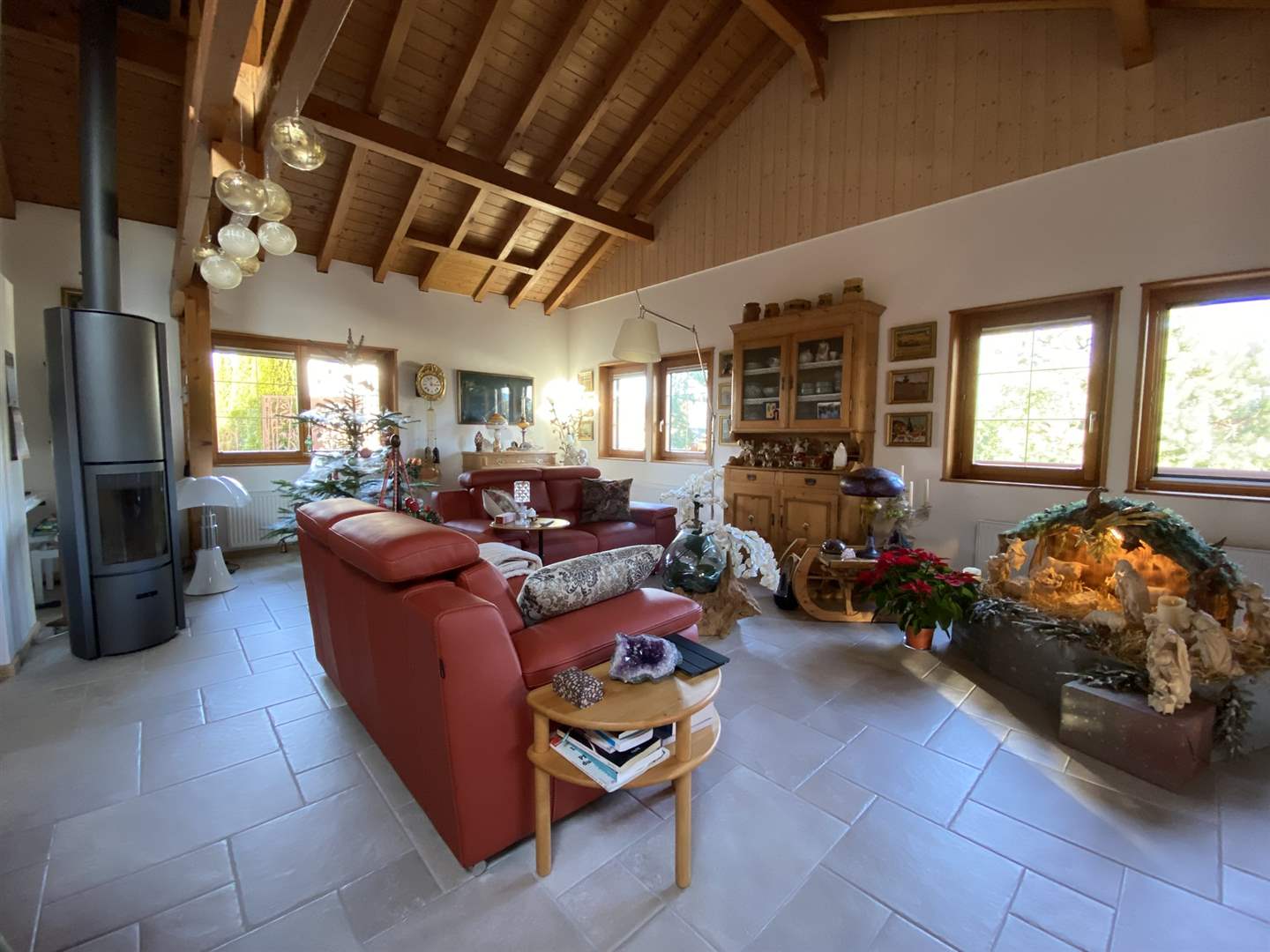 Gemütliches Wohnzimmer mit Holzdecke und Kaminofen