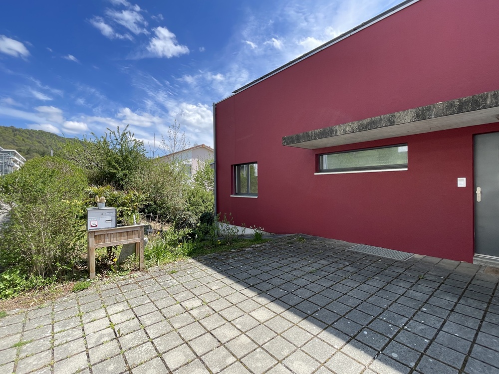 Rotes Einfamilienhaus mit gepflastertem Vorplatz