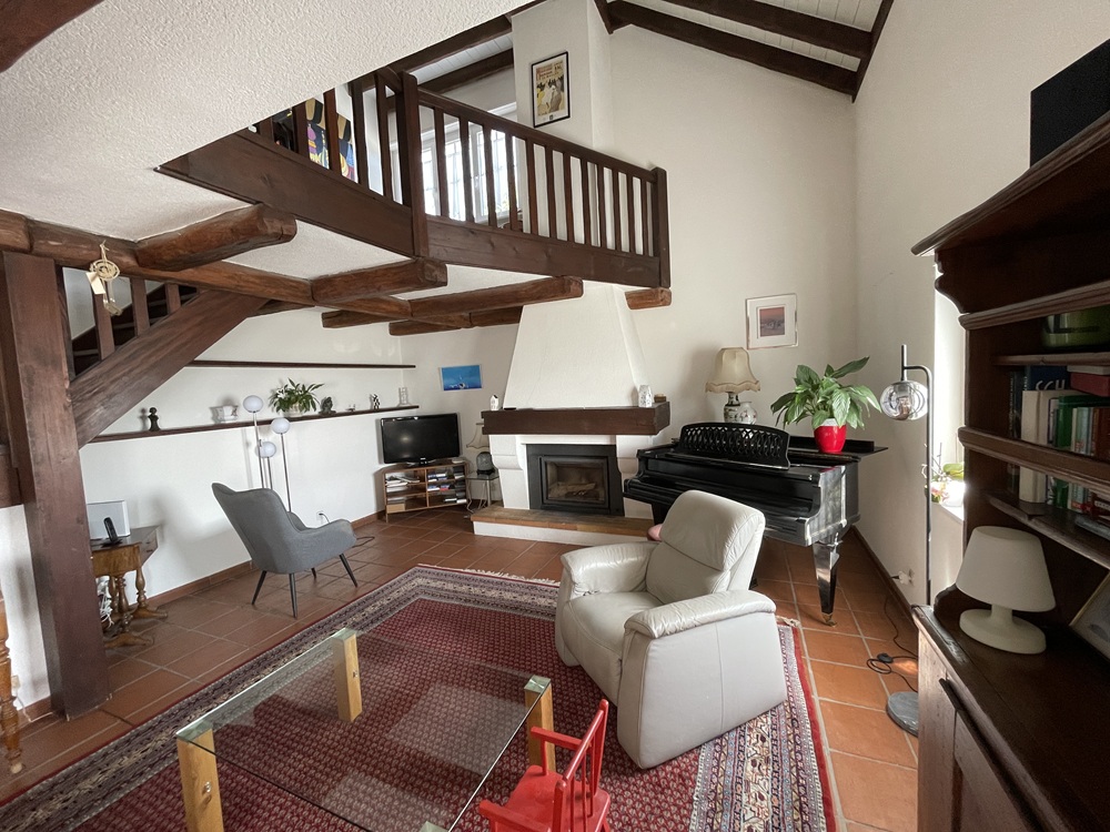 Wohnzimmer mit sichtbarer Galerie und Kamin
