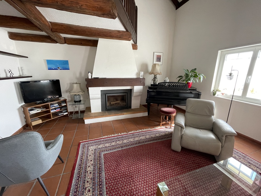 Wohnzimmer mit Kamin und rustikalen Balken