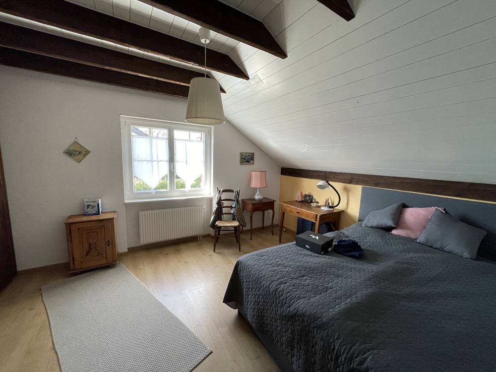 Dachgeschoss-Schlafzimmer mit sichtbaren Balken