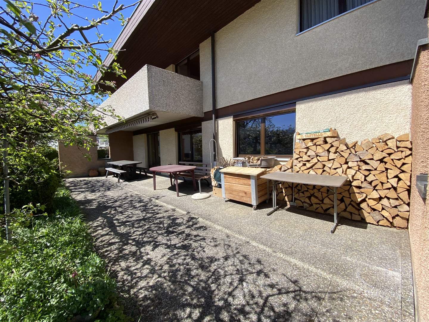 Terrasse mit Holzstapel an einem Wohnhaus