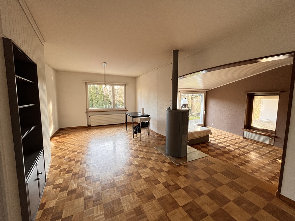 Wohnzimmer mit Ofen und Parkettboden