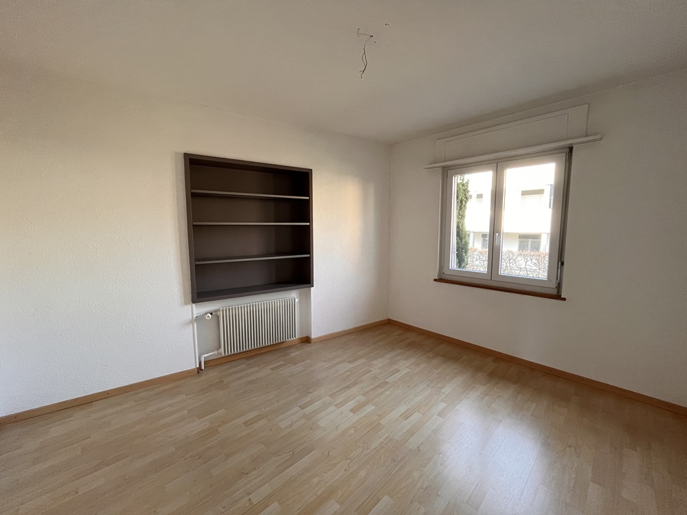 Leerer Wohnraum mit Fenster und Heizkörper