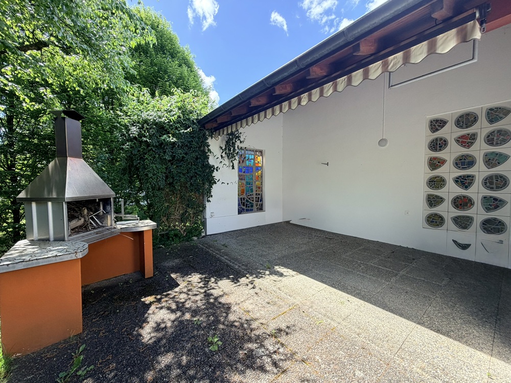 Überdachter Außenbereich mit Grill und Wanddekor