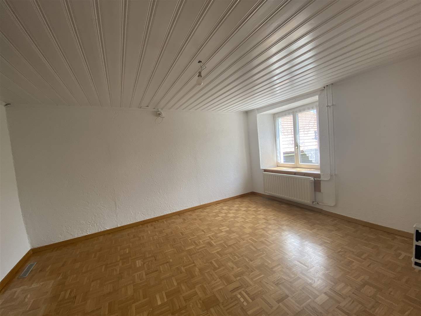 Leerer Raum mit Fenster und Holzsockel