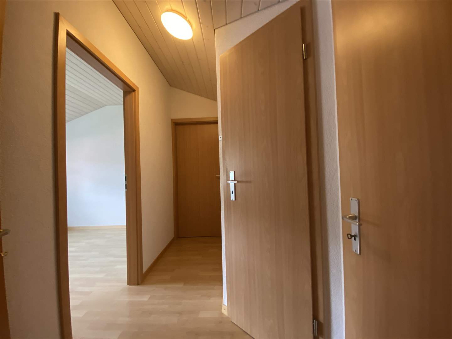 Heller Flur mit geöffneten Holztüren