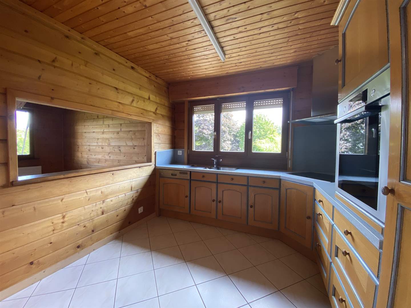 Holzverkleidete Küche mit Fensterfront